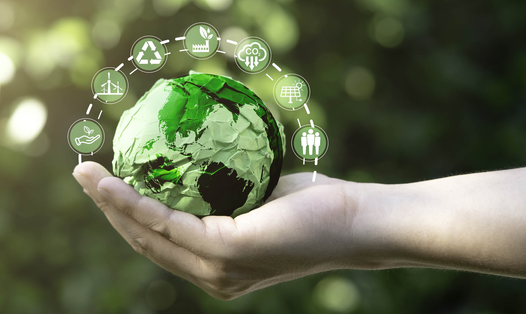 Businessman holding green scrap paper ball with world map and environment icon such as carbon reduction green factory recycle and solar cell for zero carbon emission credit to prevent global warming.